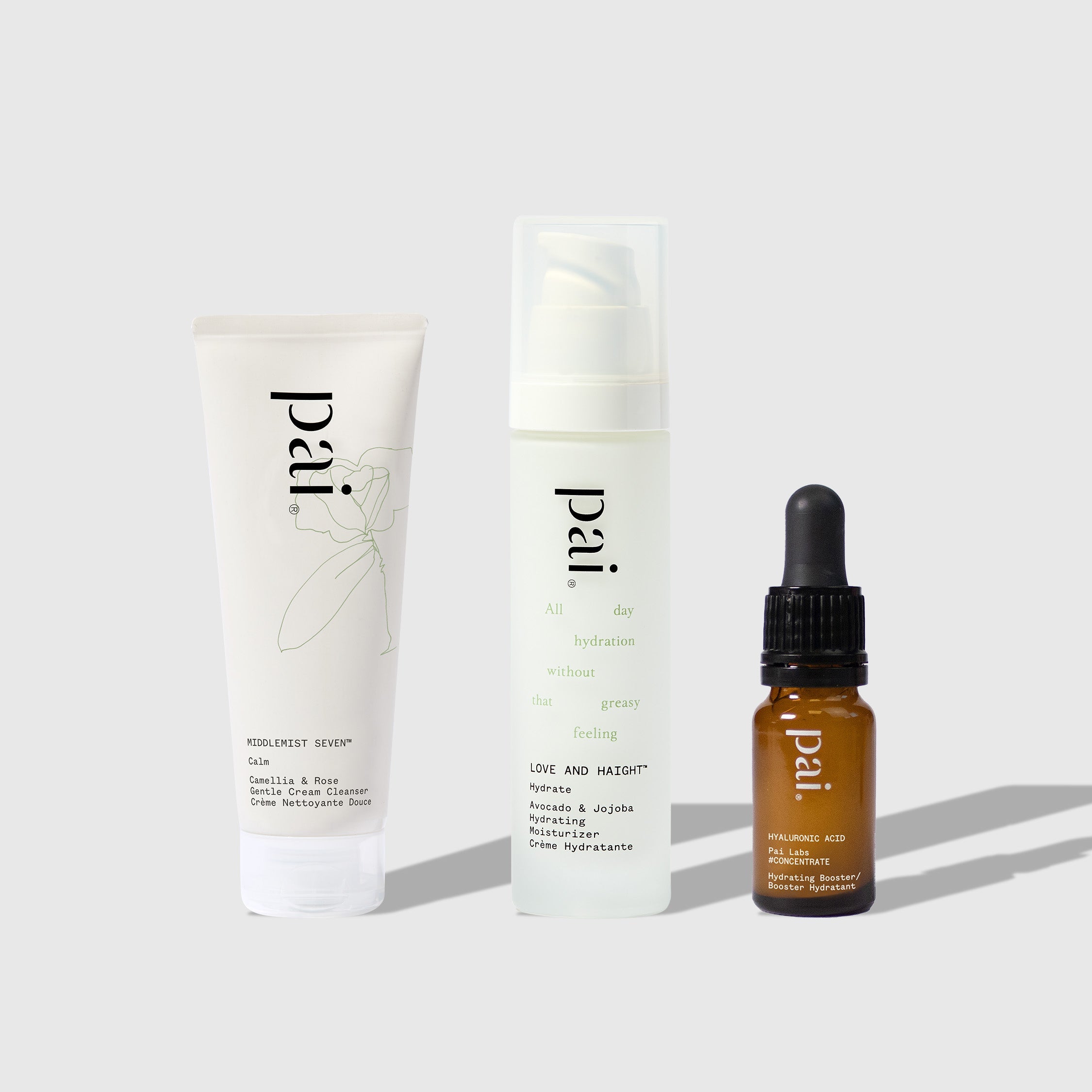 Three Pai Skincare products arranged on white surface: Middlemist Seven cleanser tube, Love and Haight moisturizer pump bottle, and Hyaluronic Acid serum dropper bottle